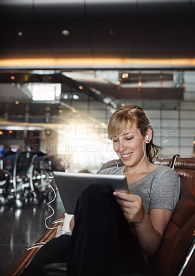 Buy stock photo Cropped shot of an attractive young woman using a tablet in an airport