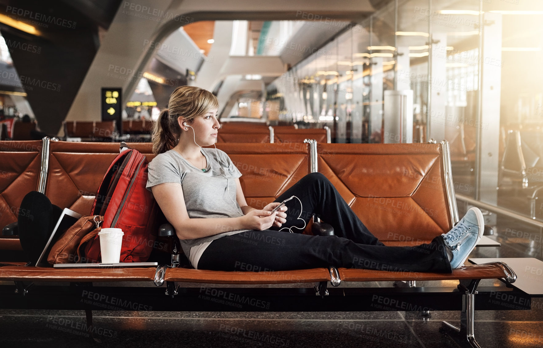 Buy stock photo Full length shot of an attractive young woman using a cellphone in an airport