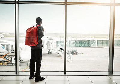 Buy stock photo Rearview shot of a man looking through the window at an airport