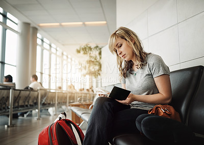 Buy stock photo Cropped shot of an attractive young woman waiting for her flight in an airport