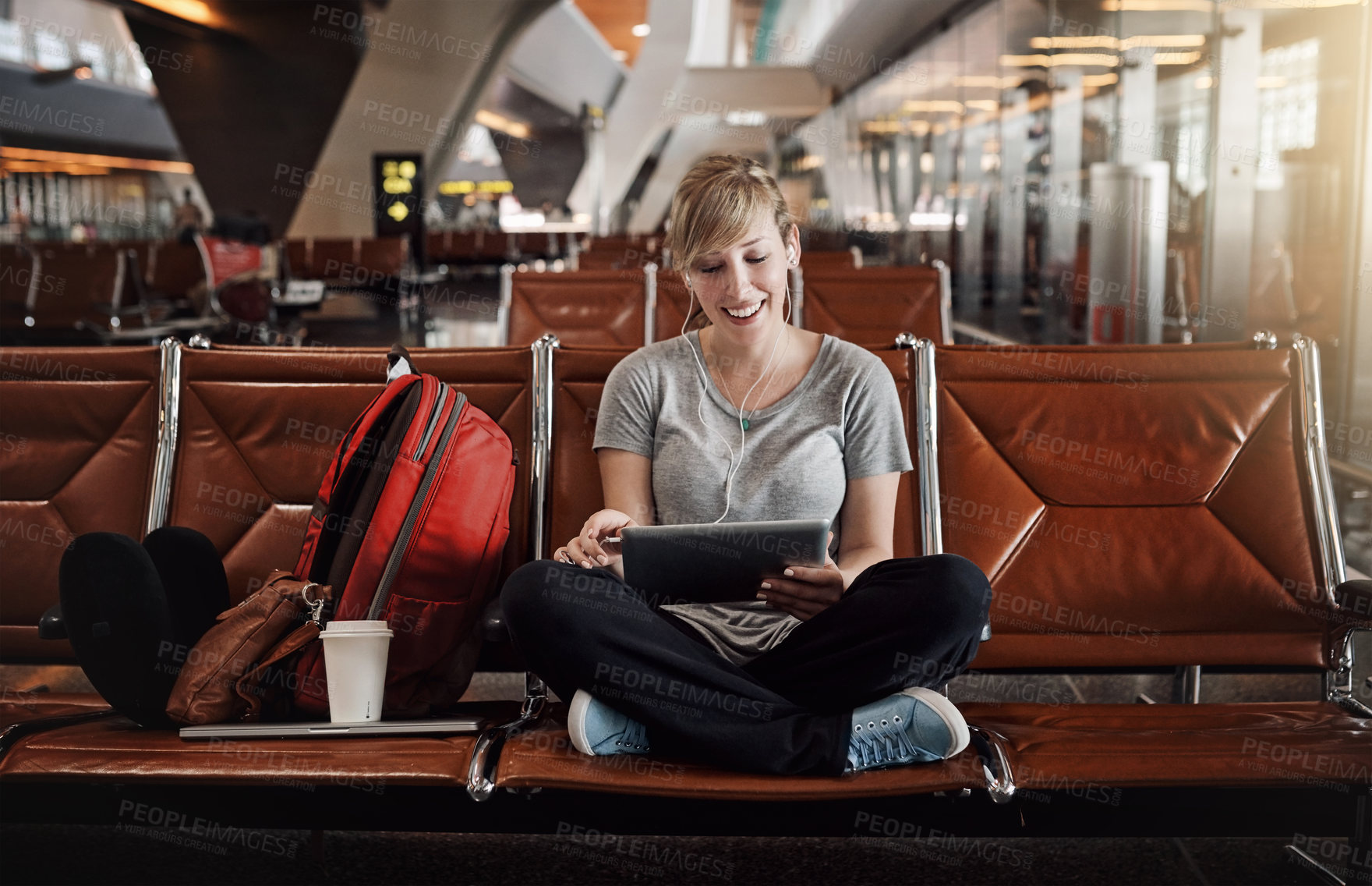 Buy stock photo Full length shot of an attractive young woman using a tablet in an airport