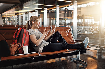 Buy stock photo Full length shot of an attractive young woman using a tablet in an airport