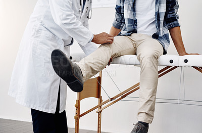 Buy stock photo Cropped shot of an unrecognizable male doctor doing a check up on a young patient who's seated on a doctor's bed