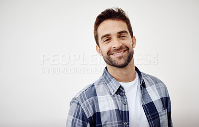 Buy stock photo Studio portrait of a cheerful young man standing against a white background while looking directly at the camera