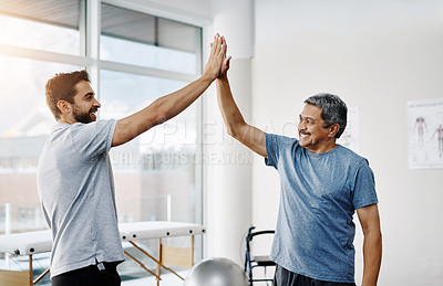 Buy stock photo Cropped shot of two cheerful men giving each other a high five on a successful day of excise in a clinic