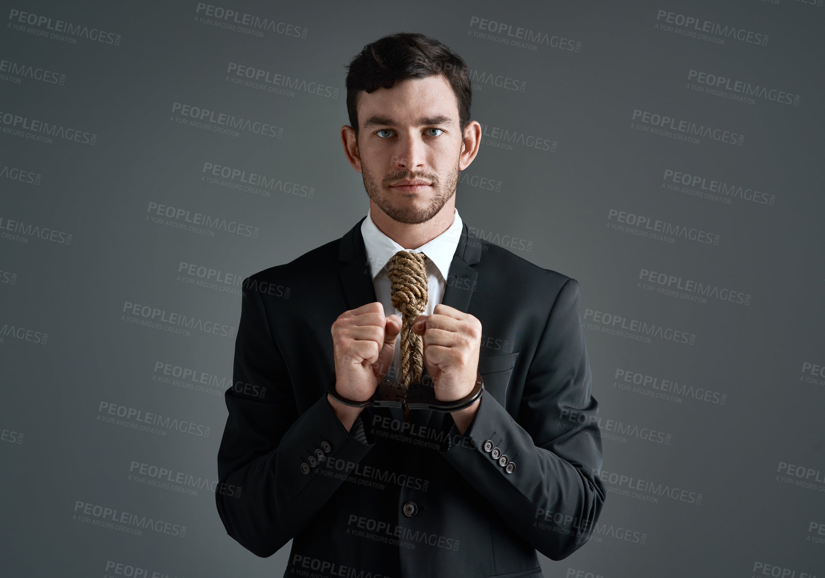 Buy stock photo Businessman, portrait and noose tie with handcuffs, finance debt and economy pressure. Model, corporate stress and cost crisis with financial bondage, failure and execution on gray studio background