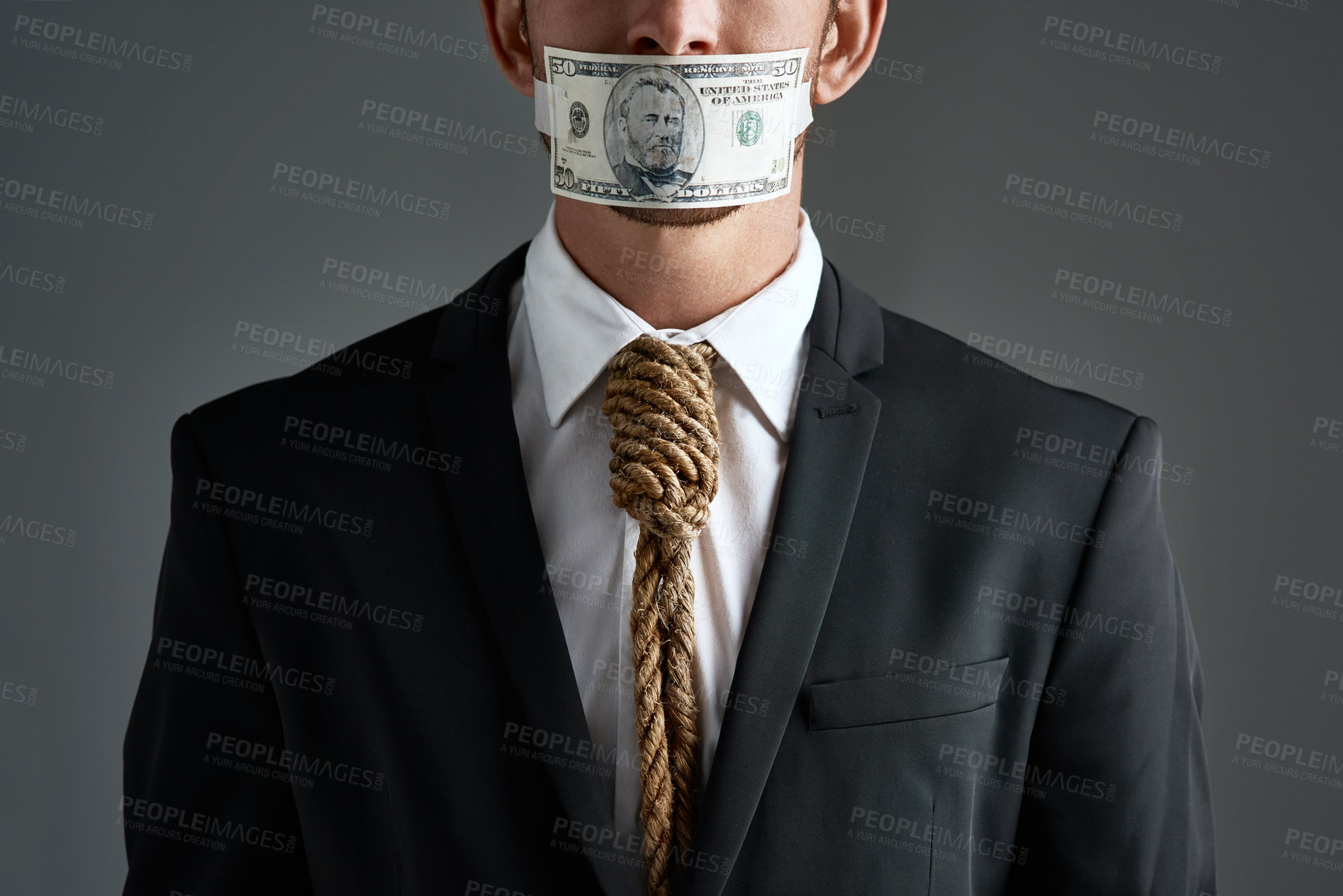 Buy stock photo Studio shot of a businessman with rope around his neck and money taped over his mouth against a gray background