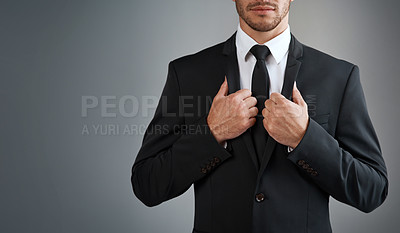 Buy stock photo Cropped studio shot of a young businessman dressed in a suit against a grey background