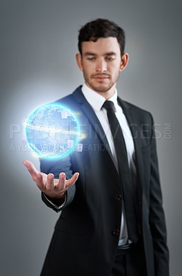Buy stock photo Studio shot of a young businessman holding a glowing orb against a gray background
