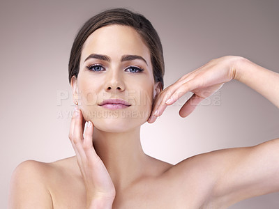 Buy stock photo Studio portrait of a beautiful young woman touching the soft skin on her face against a pink background