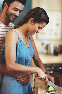 Buy stock photo Kitchen, couple and hug with knife, cucumber and food cutting in home with smile, love and care. Cooking, salad and vegetable with happy people with bonding, support and marriage with wellness