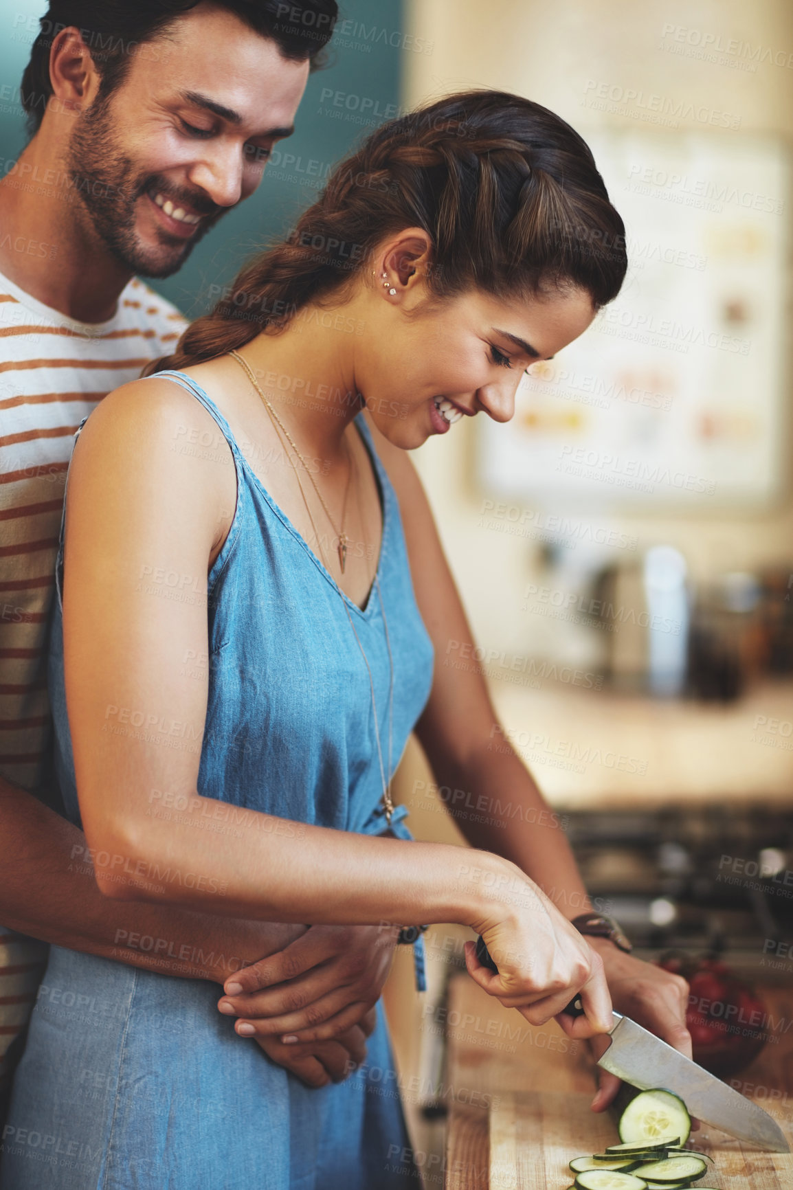 Buy stock photo Kitchen, couple and hug with knife, cucumber and food cutting in home with smile, love and care. Cooking, salad and vegetable with happy people with bonding, support and marriage with wellness