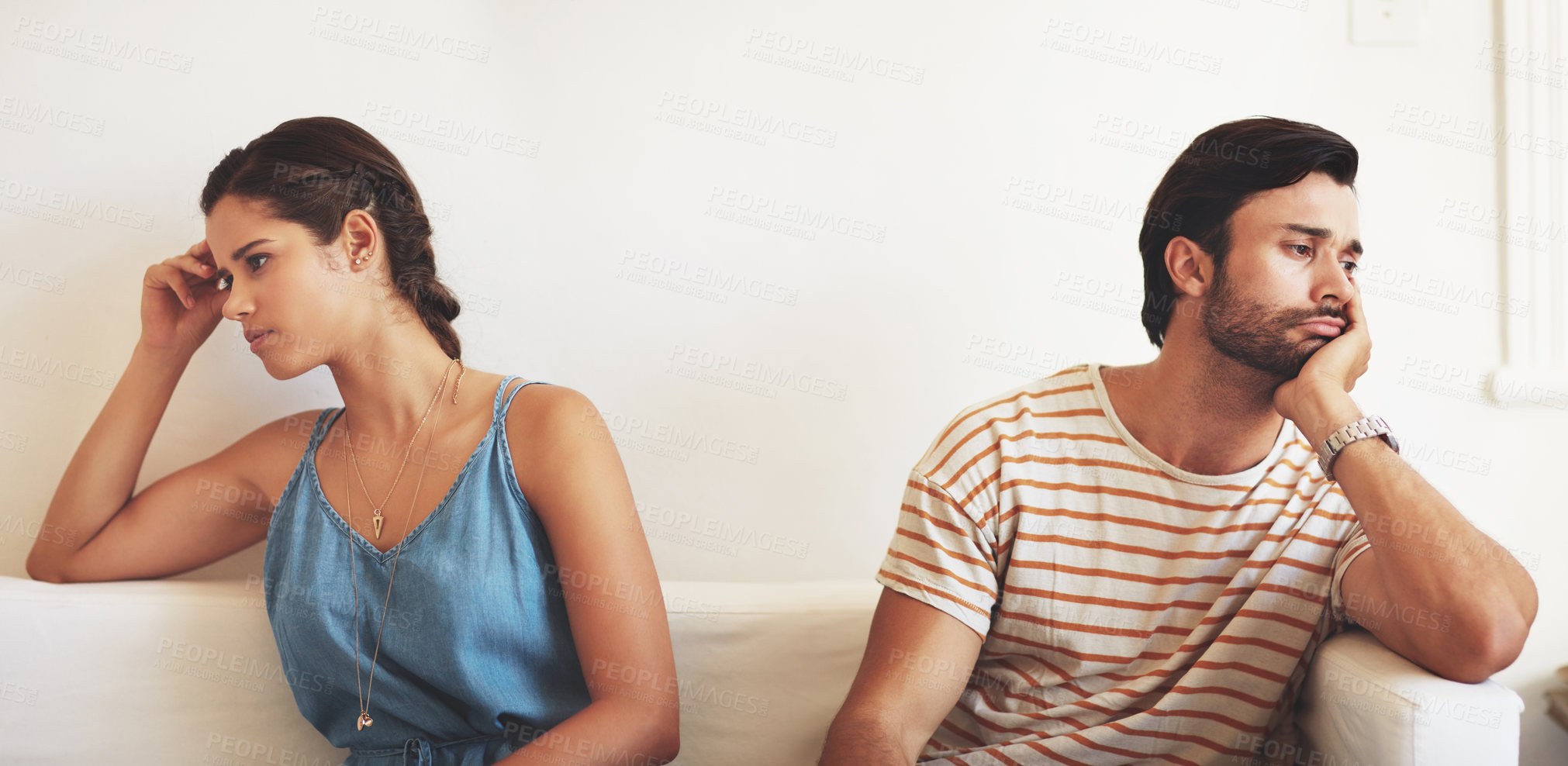 Buy stock photo Shot of a young couple having an argument while sitting on their couch at home