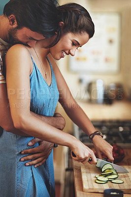 Buy stock photo Home, couple and hug with knife, vegetable and food cutting in kitchen with smile, love and care. Cooking, salad and cucumber with happy people with bonding, support and marriage with wellness