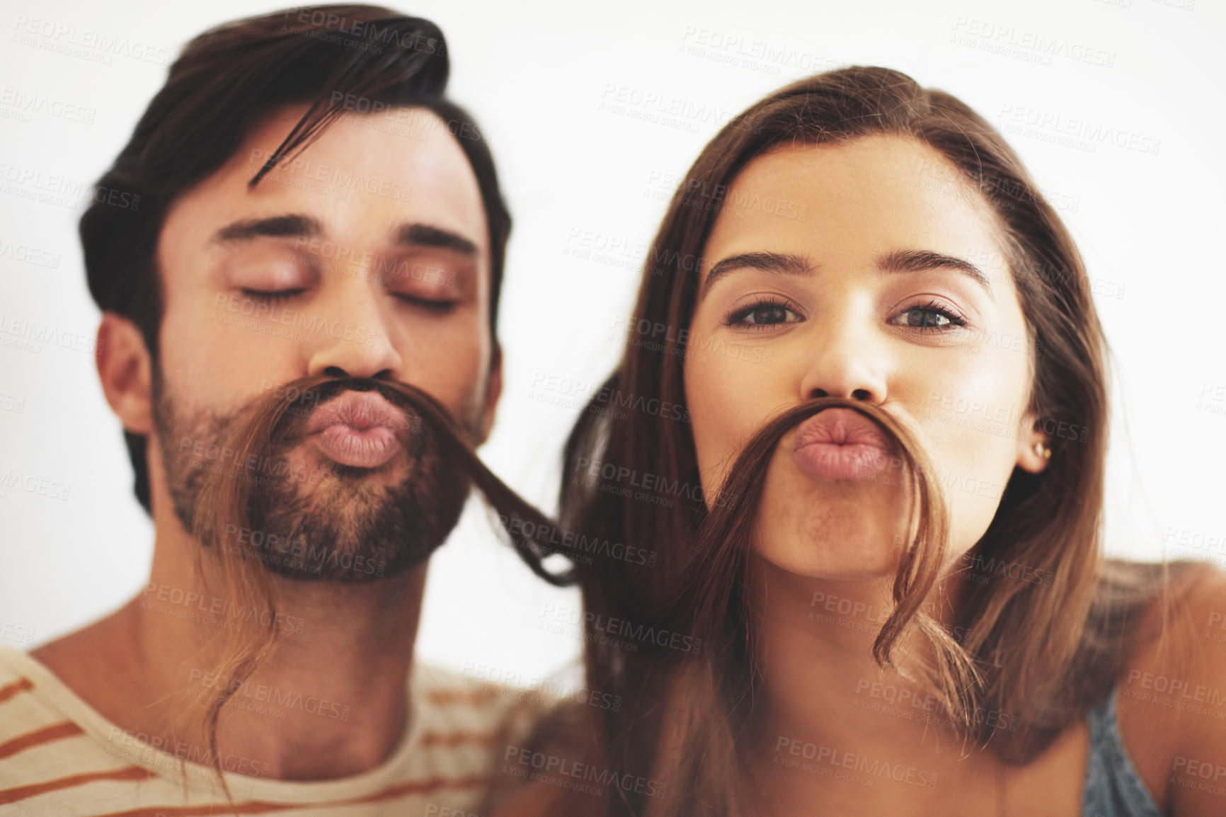 Buy stock photo Couple, home and hair mustache with meme, fun and kissing face with playful, bonding and love together. Young man, woman and silly romance for relaxing pout with care, happiness and comic joke