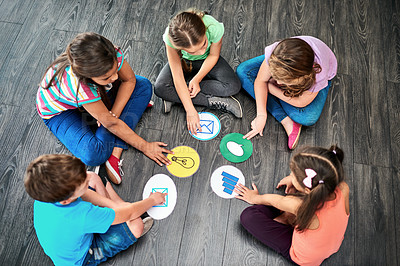 Buy stock photo Kids, group and playing a game on floor with communication icons, decision making and learning. Diversity, people and problem solving with educational activity, development or knowledge with top view