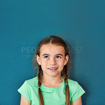 Buy stock photo Girl, kid and smile with thinking on mockup with question, imagination and curiosity on blue background. Person, uncertain child and thoughtful with wondering, daydreaming and contemplating on space