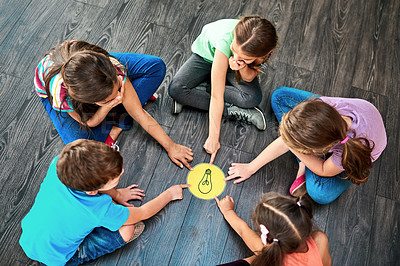 Buy stock photo Kids, pointing and playing a game on floor with lightbulb, decision making and learning. Diversity circle, people and problem solving with educational activity, solution and knowledge with top view