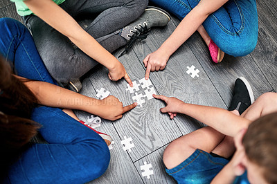 Buy stock photo Above, children and hands with puzzle for playing, cognitive development and solution skills by floor. Teamwork, kids and solidarity with jigsaw for problem solving, support and friends for bonding