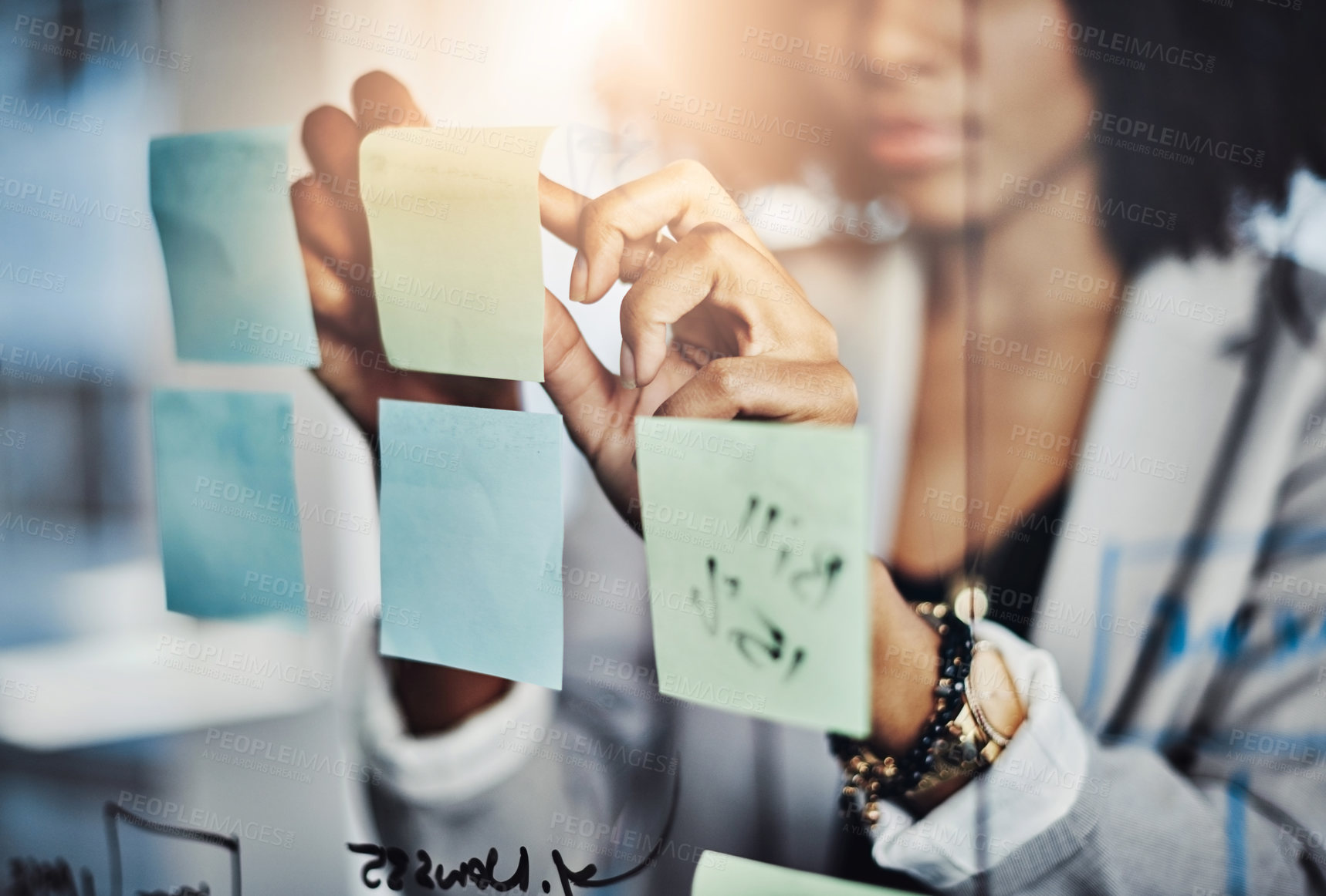 Buy stock photo Closeup shot of a businesswoman brainstorming notes on a glass wall in an office