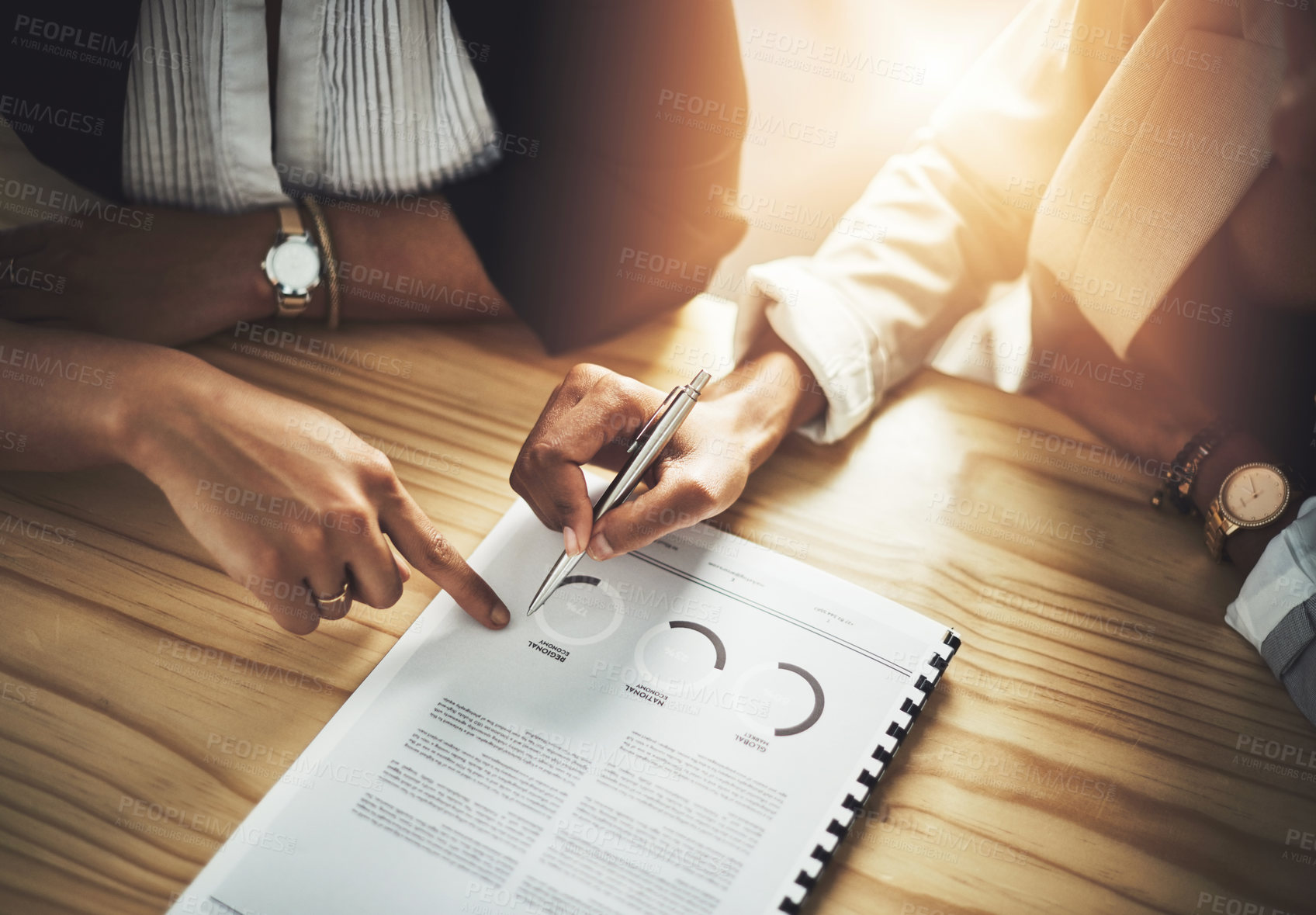 Buy stock photo Closeup shot of two businesswomen going through paperwork in an office