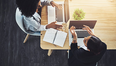 Buy stock photo High angle shot of two businesswomen having a discussion in an office