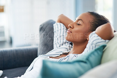 Buy stock photo Shot of a young woman sleeping on the sofa at home