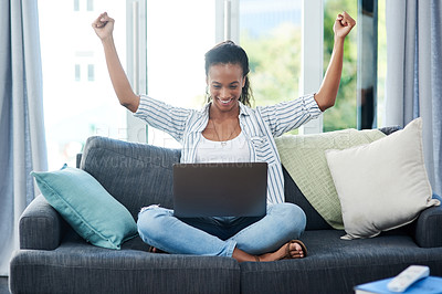 Buy stock photo Shot of a young woman cheering while using a laptop at home