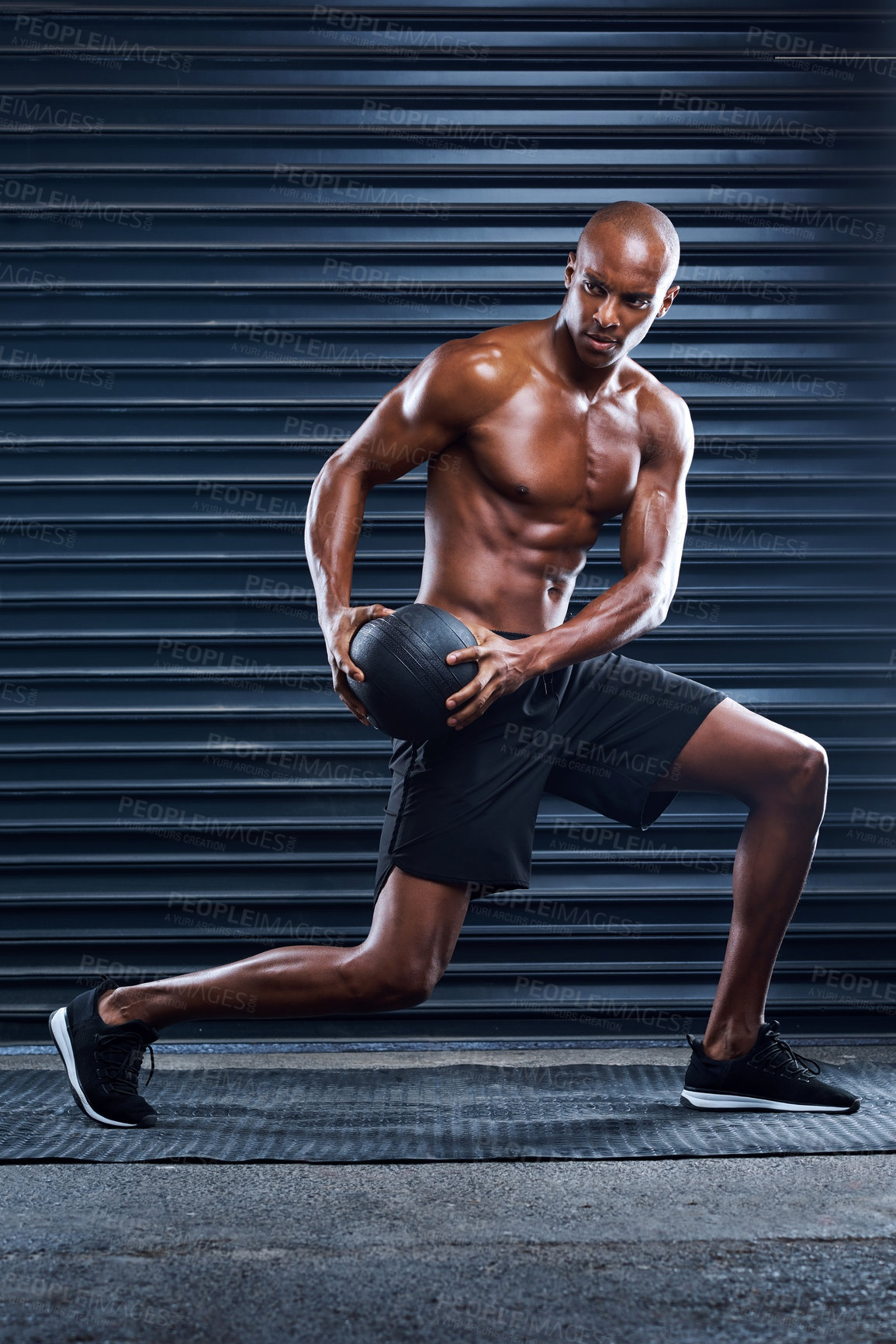 Buy stock photo Shot of a masculine man working out with a medicine ball