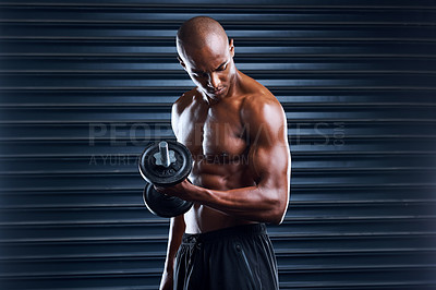 Buy stock photo Shot of a sporty young man working out with weight plates as part of his exercise routine