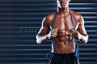 Buy stock photo Cropped shot of a sporty young man posing with a skipping rope