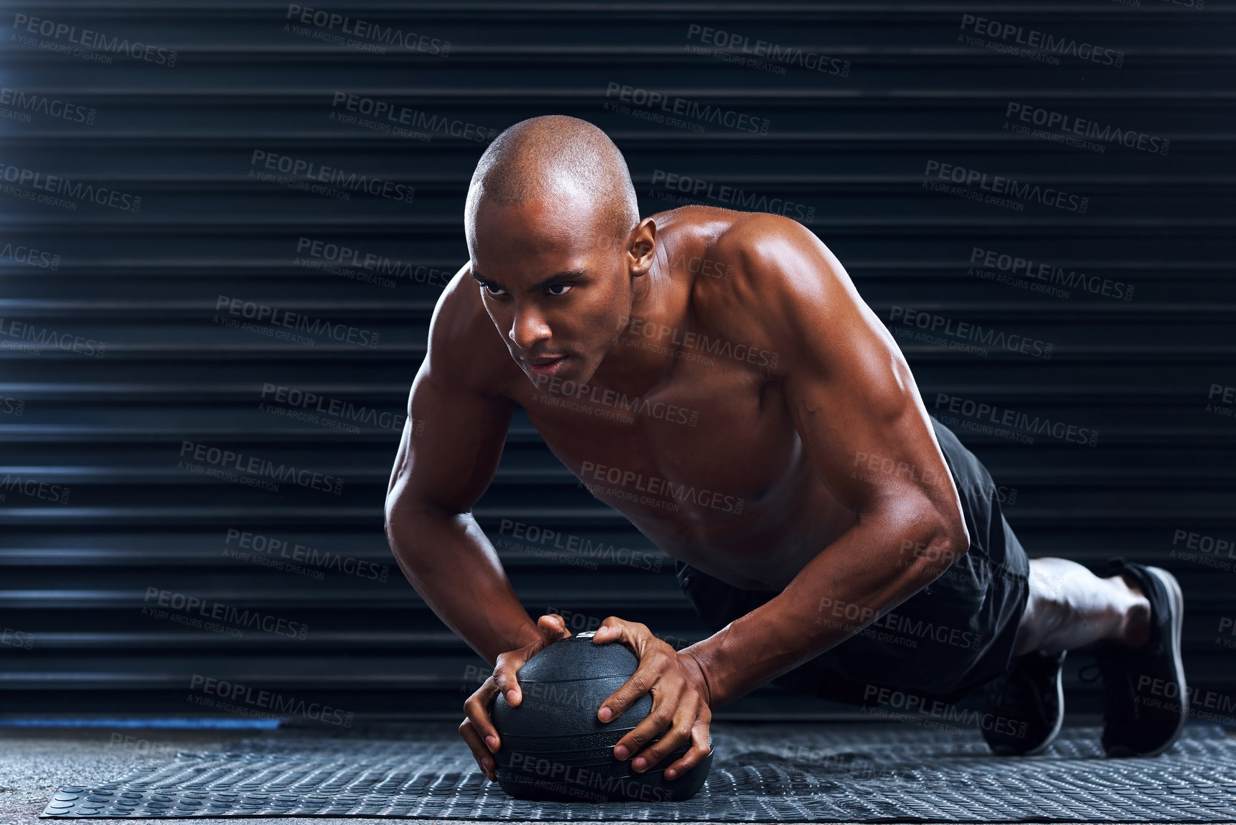 Buy stock photo Shot of a sporty young man practising his exercise routine