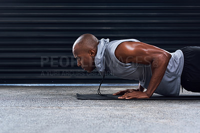 Buy stock photo Shot of a sporty young man doing push ups