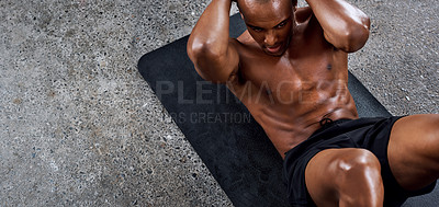 Buy stock photo Shot of a sporty young man doing sit ups as part of his exercise routine