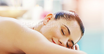 Buy stock photo Shot of a young woman relaxing on a massage bed at a spa