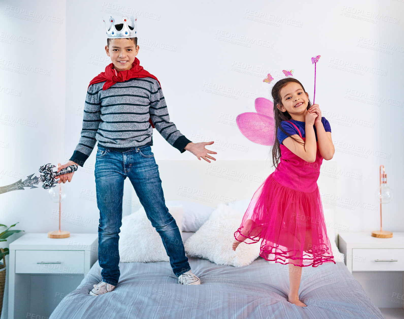 Buy stock photo Bed, playing and portrait of children in costume for sibling bonding, relax and fun together. Family, happy and young girl and boy for childhood, youth and playful on holiday, weekend and vacation