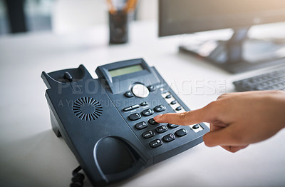 Buy stock photo Cropped shot of an unrecognizable businesswoman using the landline at work