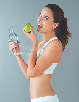 Buy stock photo Woman, portrait and health with water, apple and bottle on studio background for wellness and hydration. Female person, happy and fitness with h20, fruit and smile for nutrition, diet and weight loss