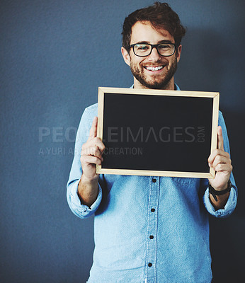 Buy stock photo Studio portrait of a young man holding a blackboard against a grey background