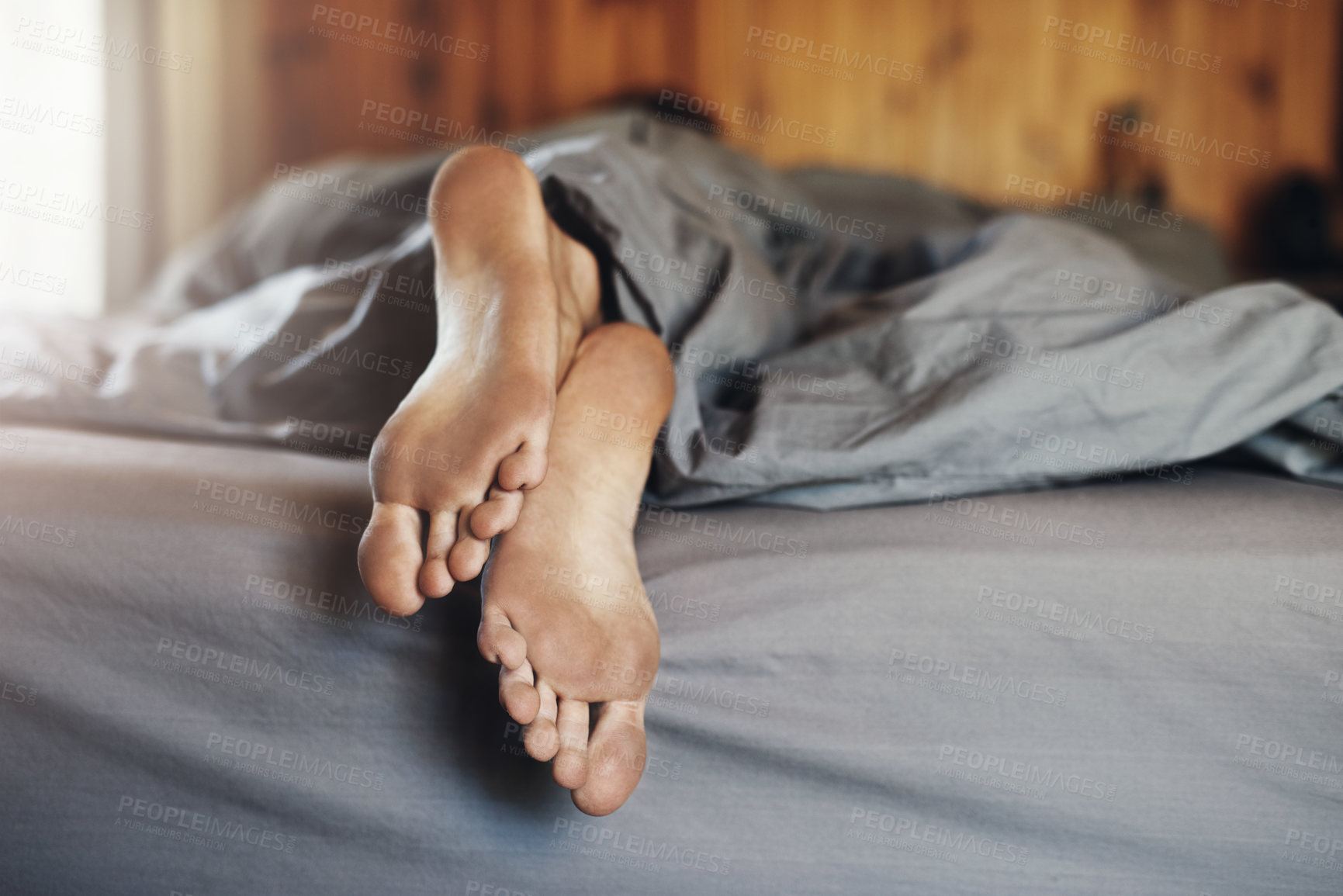 Buy stock photo Closeup shot of a man's dirty feet while he's sleeping in bed