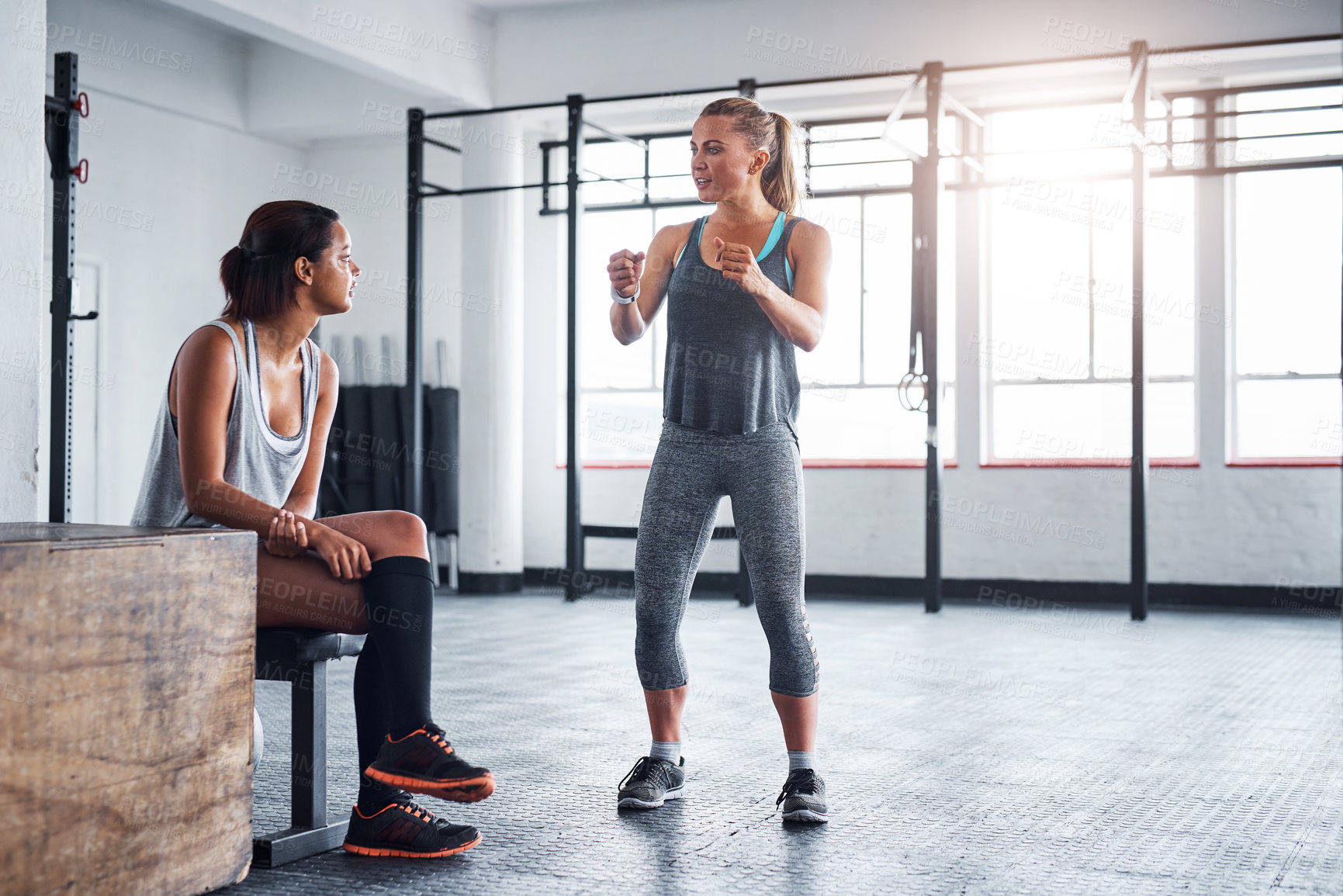 Buy stock photo Shot of a fitness instructor talking to her client in a gym