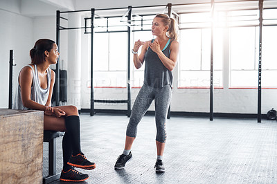 Buy stock photo Shot of a fitness instructor talking to her client in a gym