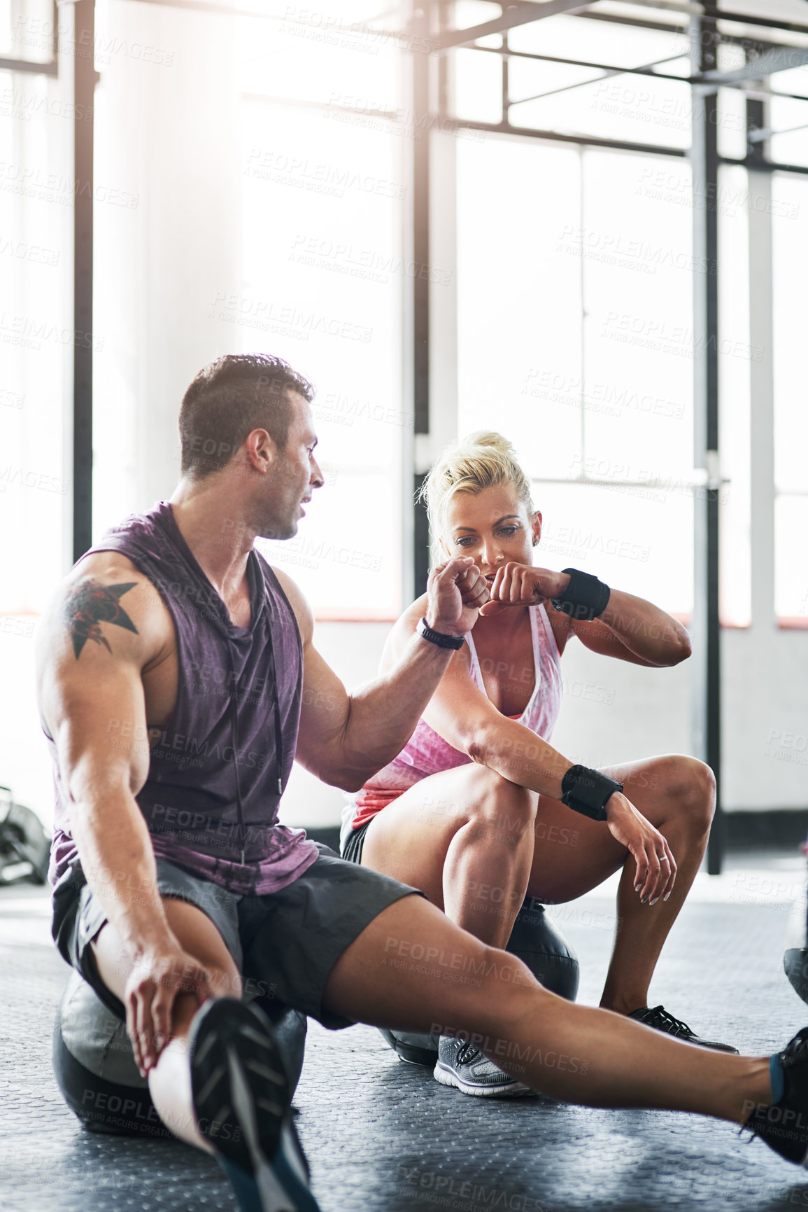 Buy stock photo Shot of a man and a woman giving each other a fist pump after a workout at the gym