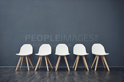 Buy stock photo Recruitment, chairs and row on gray wall with vacancy, waiting room and job interview. Hiring, background and employment with company interior, work opportunity and queue for human resources line