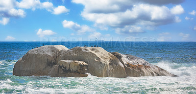 Buy stock photo Scenic view of sea, rocks, and waves in Camps Bay Beach, Cape Town, South Africa. Tidal ocean with shoreline rocks and boulders. Overseas travel and tourism destination with blue sky and copy space