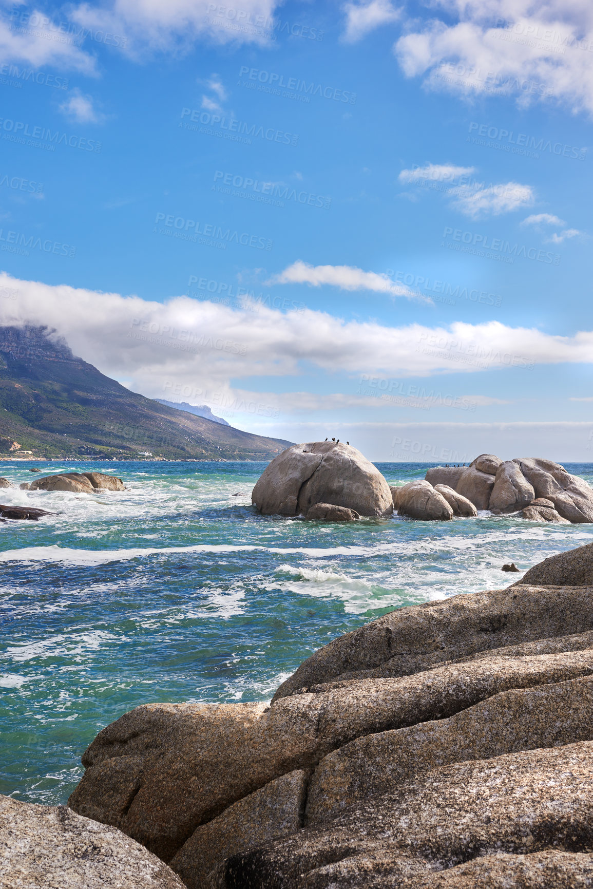 Buy stock photo Landscape view of sea water, rocks and a blue sky with copy space in Camps Bay Beach, Cape Town, South Africa. Calm, serene, tranquil, ocean and relaxing nature scenery. Waves washing on rocky shore