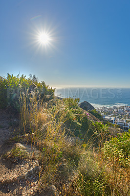 Buy stock photo View of the horizon over the ocean and under a clear blue sky with the sun and copy space. The seascape scenery from the peak or top of Lions Head mountain in Cape Town, South Africa