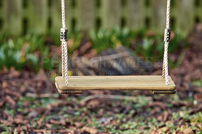 Buy stock photo An empty wooden swing in a garden outside in the late afternoon with copyspace. A space to play in a backyard for active children wanting to have fun and play with copy space 