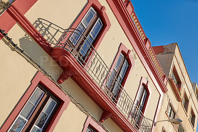 Buy stock photo Houses or homes built in vintage architecture design in a small town village. Residential building or apartment with big windows and a balcony against a clear blue sky in Santa Cruz de La Palma