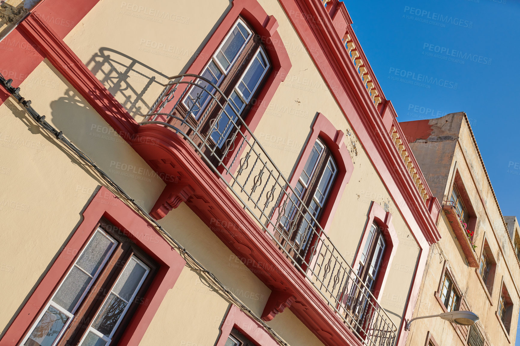 Buy stock photo Houses or homes built in vintage architecture design in a small town village. Residential building or apartment with big windows and a balcony against a clear blue sky in Santa Cruz de La Palma